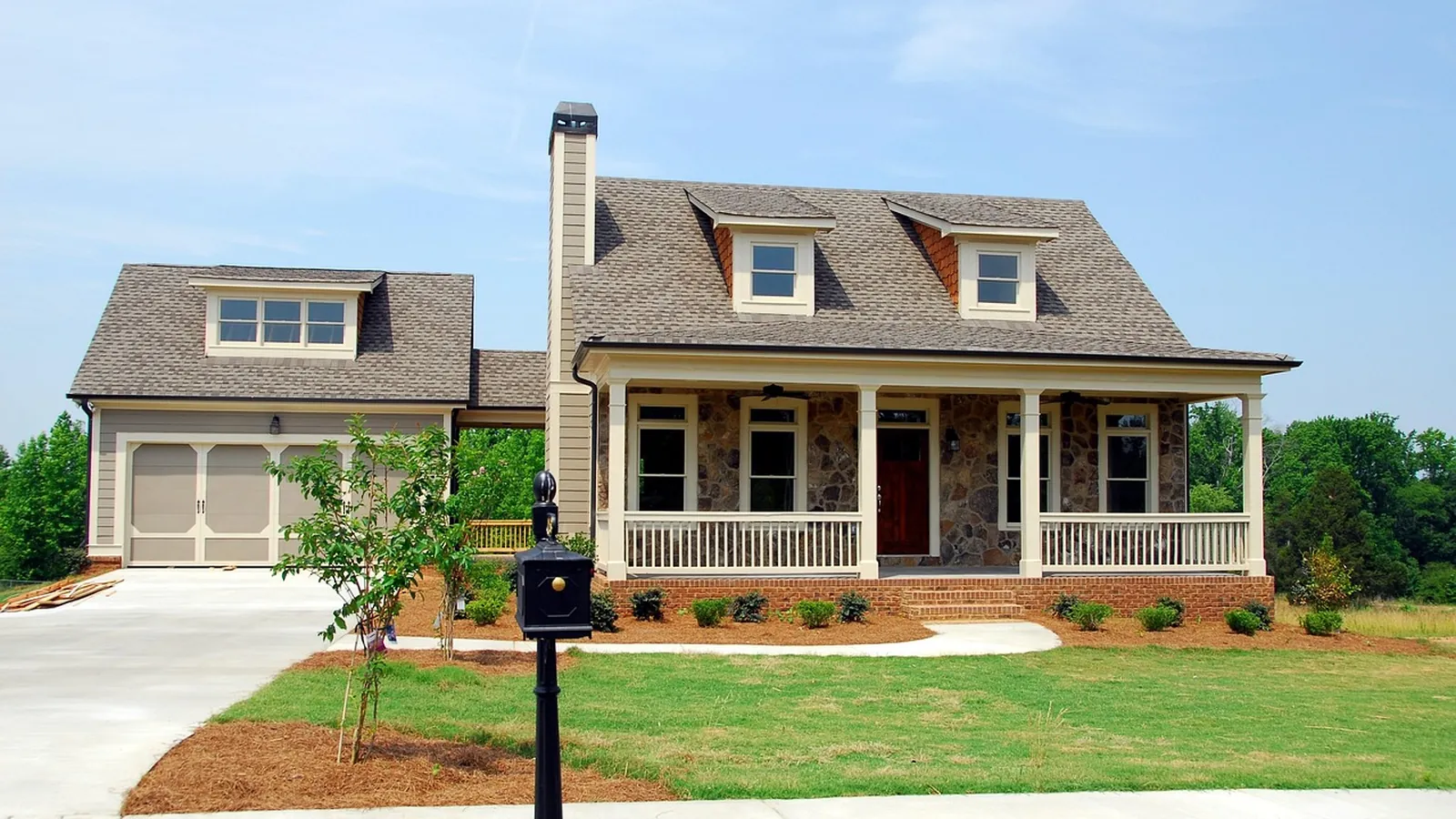 A large family home with a covered porch and clean siding on a bright day
