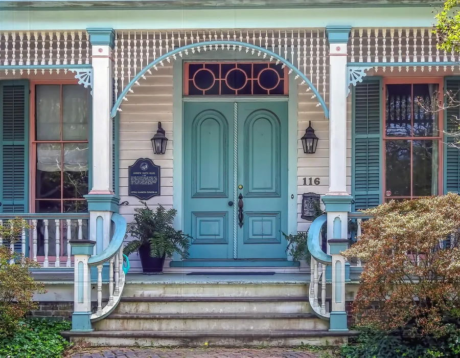 A front porch with a repainted blue door, clean white trim and washed steps